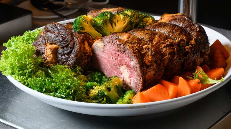Roast beef on a platter with vegetables