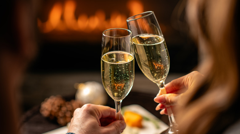 Sparkling wine in flutes by a fire