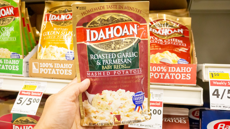 Instant mashed potatoes in a packet on a grocery store shelf.