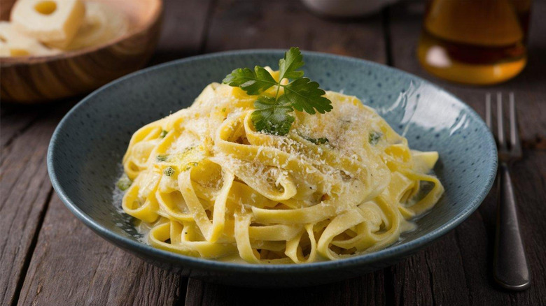 Sepiring pasta Alfredo yang disayangi ringan di atasnya dengan keju parut.