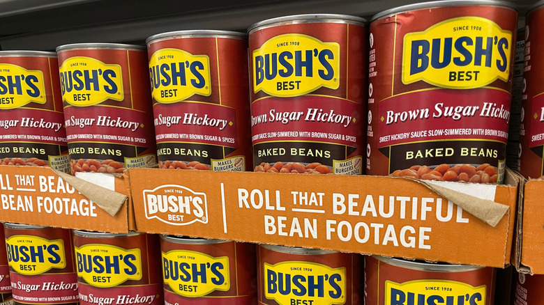 Cans of Bush's baked beans on a grocery store shelf