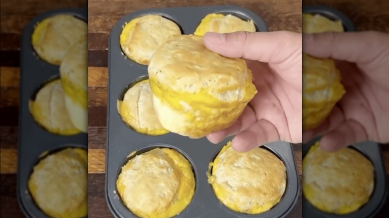 person holding up freshly baked biscuit sandwich