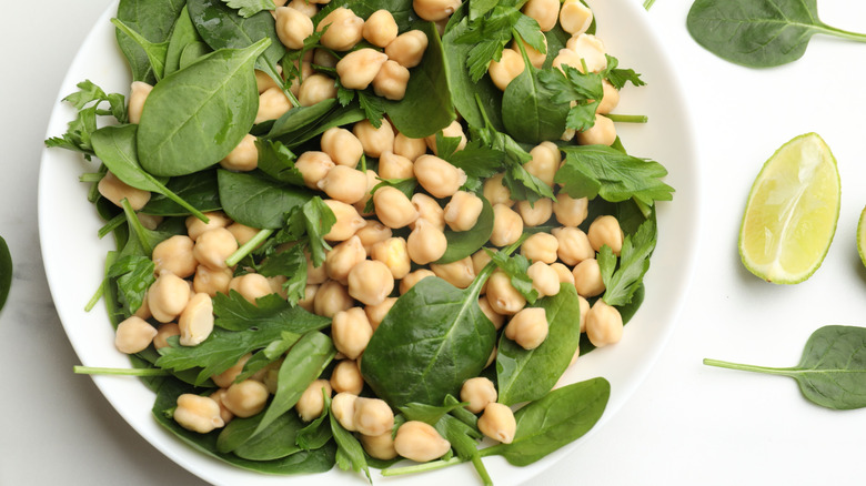 A bowl of chickpeas and fresh spinach.