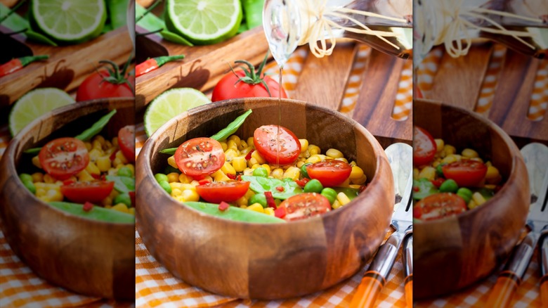 Pouring dressing into a corn salad