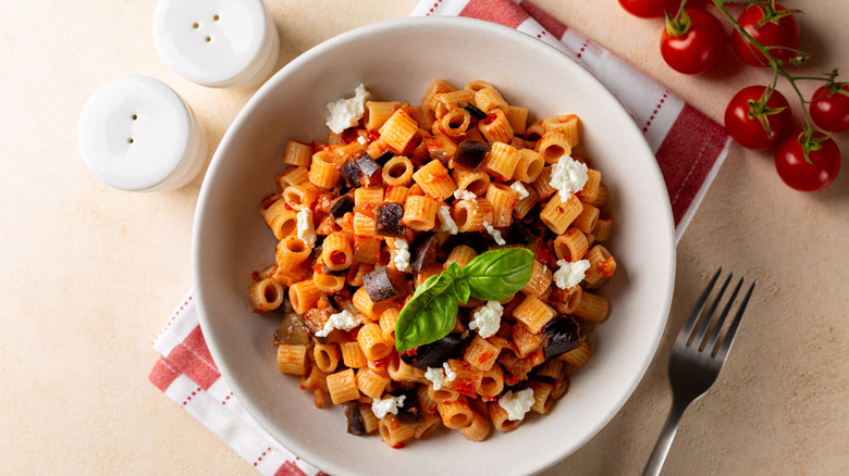 Pasta with eggplant and tomato sauce in a white bowl