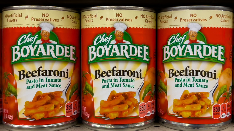 Cans of Beefaroni on a grocery store shelf