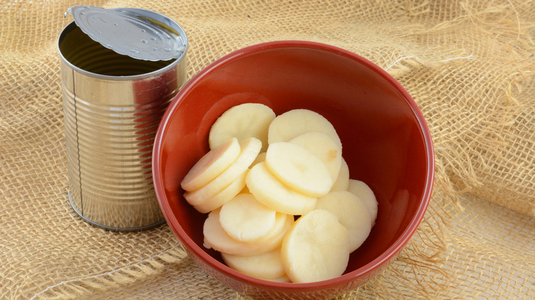 Canned potatoes in a bowl next to can.