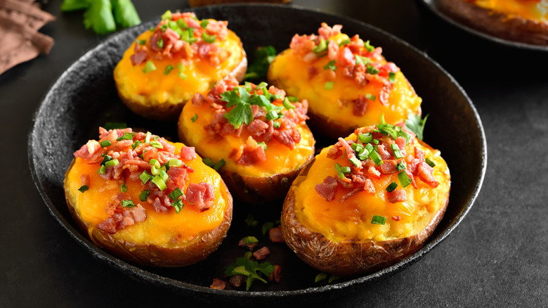 Five baked potatoes with cheese and bacon