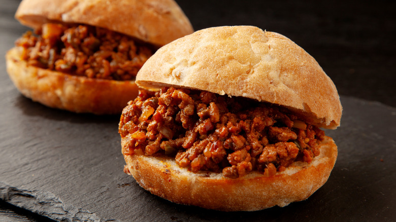 Sloppy joe sandwiches on a dark gray slate board