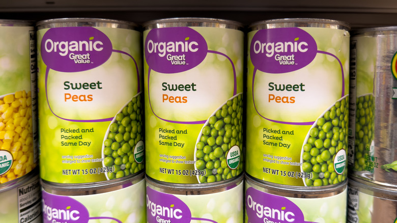 Great Value organic sweet peas cans stacked on shelf inside supermarket grocery section
