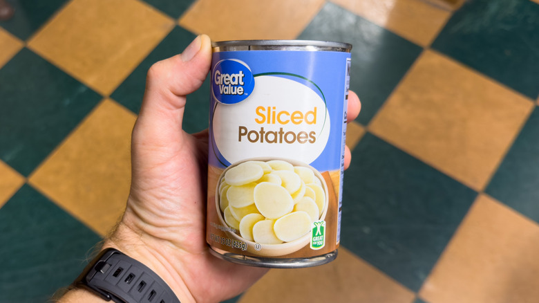 Canned sliced potatoes held by hand