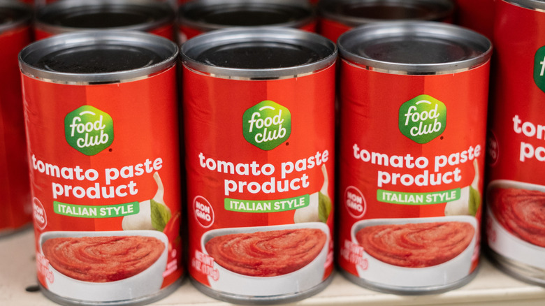 Cans of tomato paste on grocery store shelf