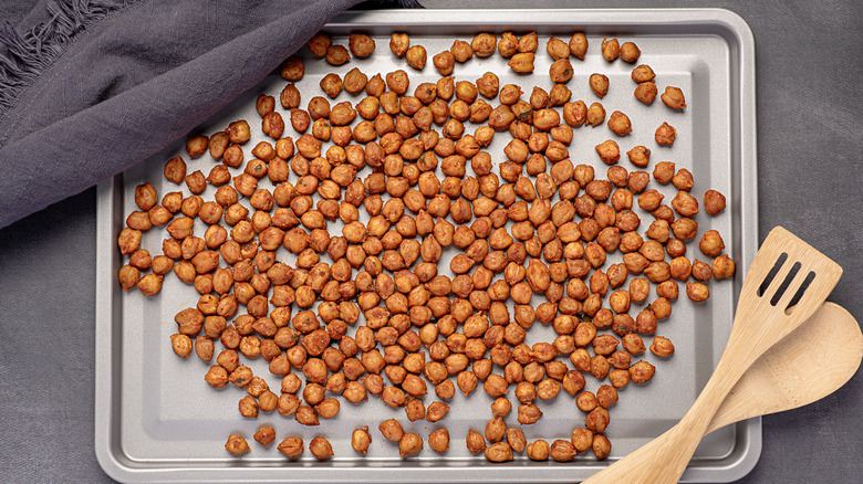 Roasted crispy chickpeas with paprika, chili and herbs on a tray