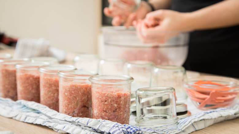 Person preparing disinfected mason jars for canning