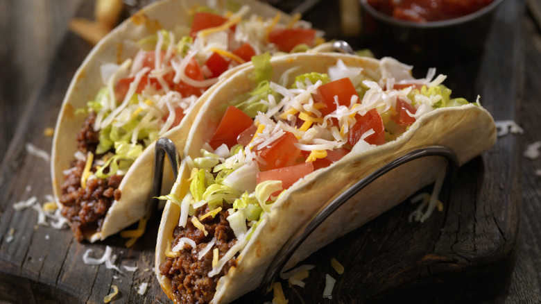 two tacos filled with meat, cheese and salad