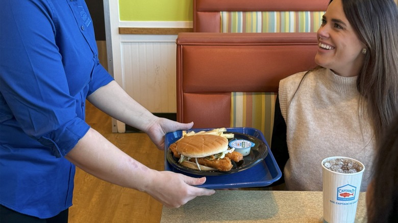 Woman being served a tray of food at a Captain D's restaurant