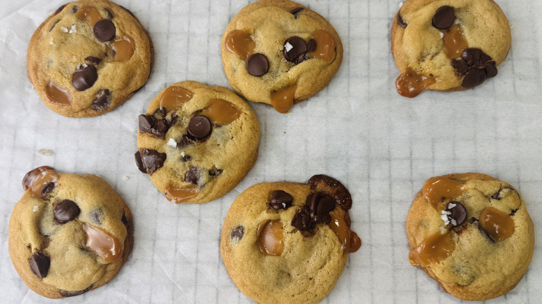 baked dark chocolate chip and caramel cookies on parchment paper
