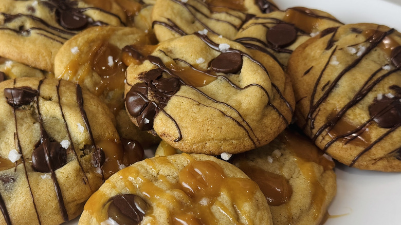 closeup of pile of chocolate chip and caramel cookies on plate