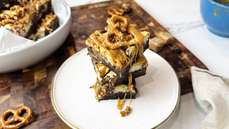 Caramel pretzel brownies stacked on plate