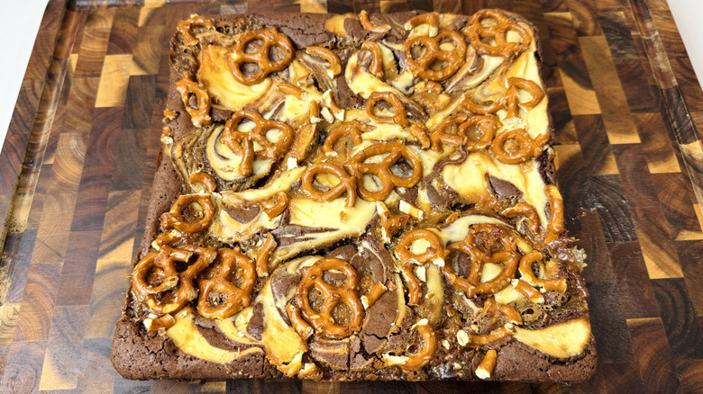 Uncut caramel pretzel brownies on cutting board