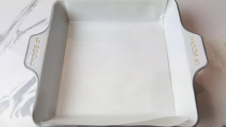 Square baking dish lined with parchment paper