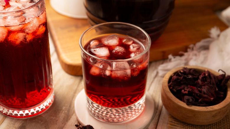 Sorrel liqueur-based cocktail on a table with dried roselles