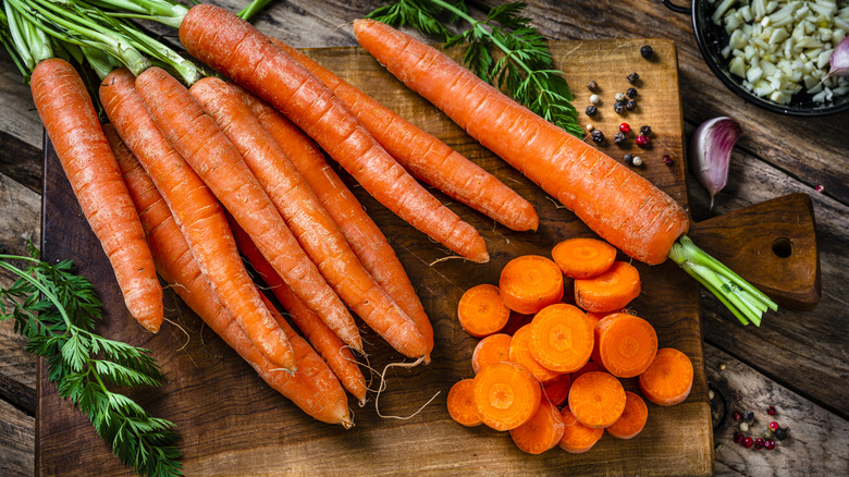 Whole carrots and carrots cut into coins on a cutting board