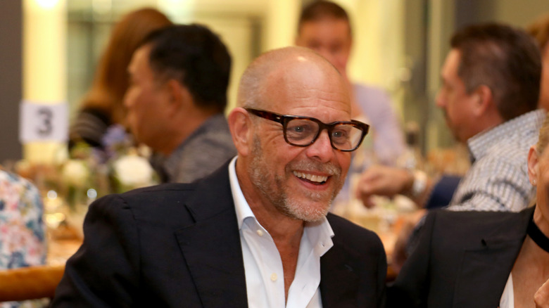 Alton Brown wearing glasses and smiling