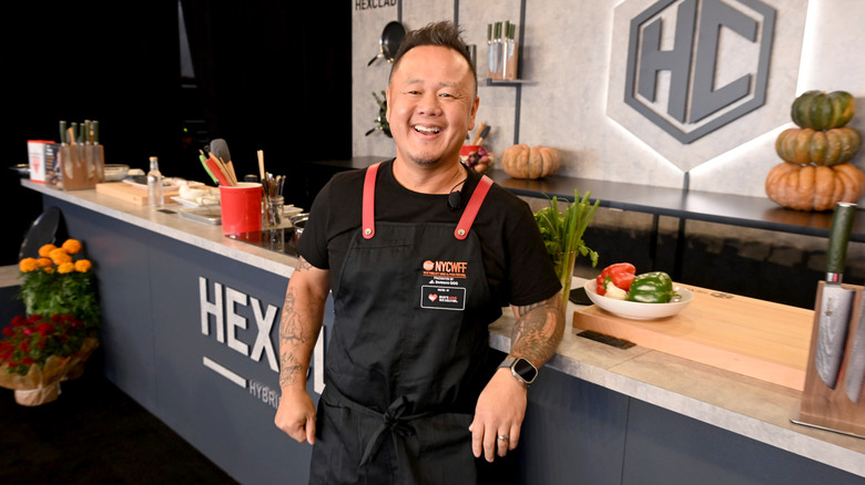 Jet Tila in front of a cooking island at a cooking event