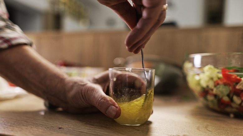 white hands making lemon dressing