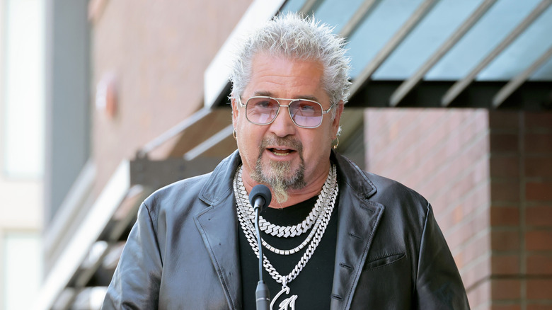 Guy Fieri at a podium speaking at an event
