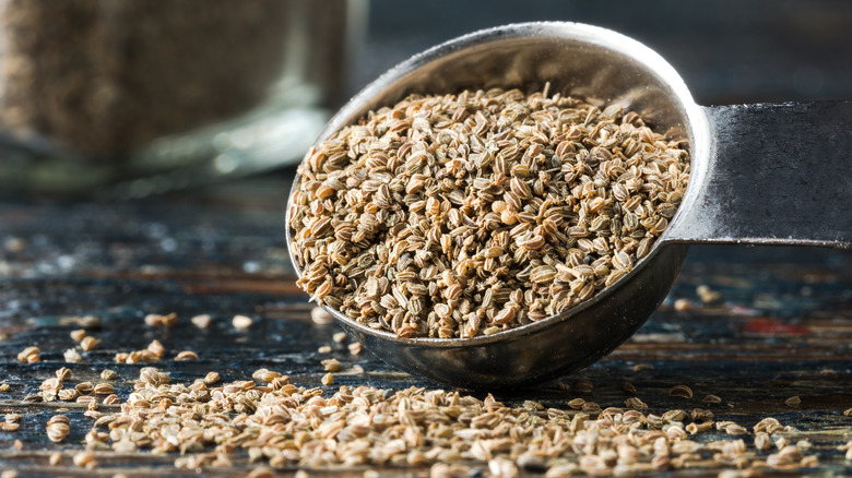 A teaspoon pouring out celery seeds.