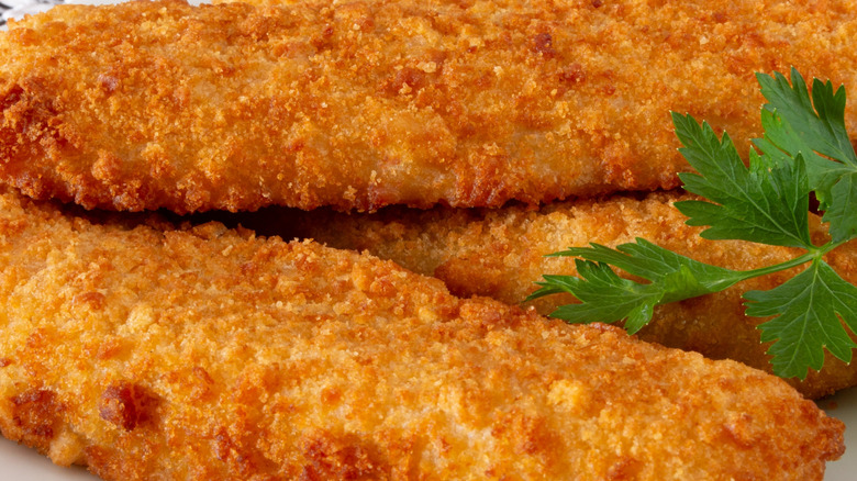 A close-up image of a breaded fish fillet that's perfectly cooked and crisped to perfection.