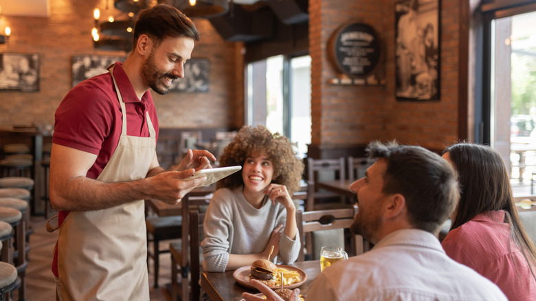Waiter talking to diners in a restaurant