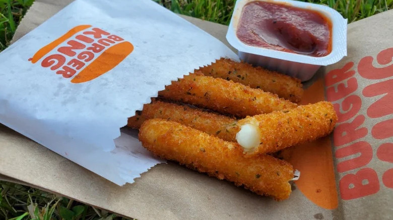 Burger King Mozzarella Fries in packaging next to container of marinara sauce