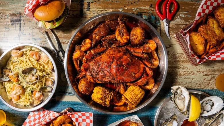 A seafood boil in a bowl with other seafood dishes at Bag O' Crab