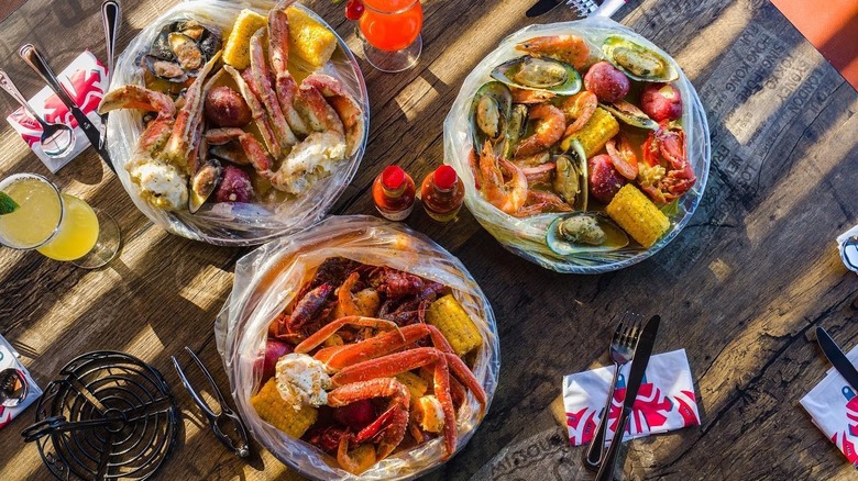Three seafood boil bags on a table at Crab du Jour