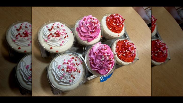 Six Dairy Queen cupcakes in a tray topped with heart sprinkles on table.