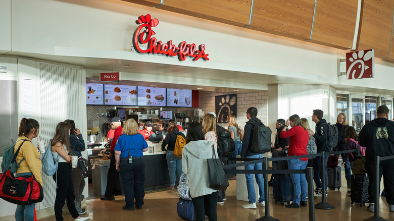 Chick-Fil-A in airport with long line of people.