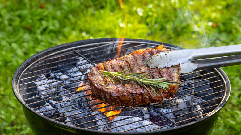 A big chunk of meat on top of a charcoal grill