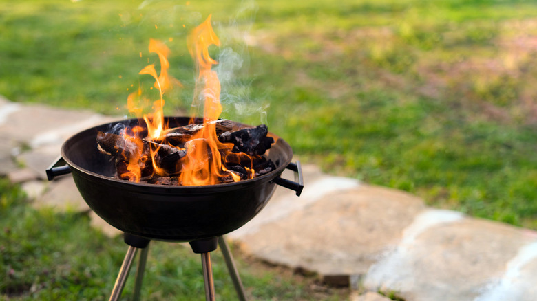 Flames reaching high on a charcoal grill outside