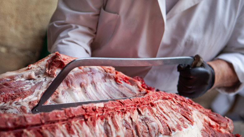 A butcher working on a pig carcass