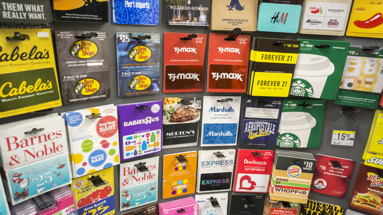 An array of gift cards for large brands and chains on display in a store.