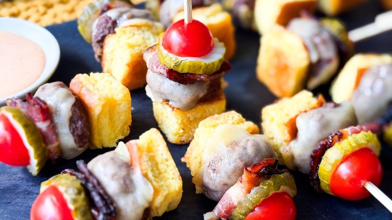 Close up of cheeseburger skewers on slate platter laying down and standing up