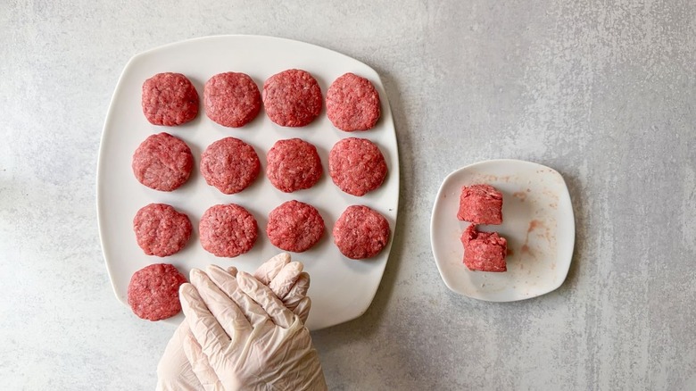 Forming ground beef into small patties on plate using gloves
