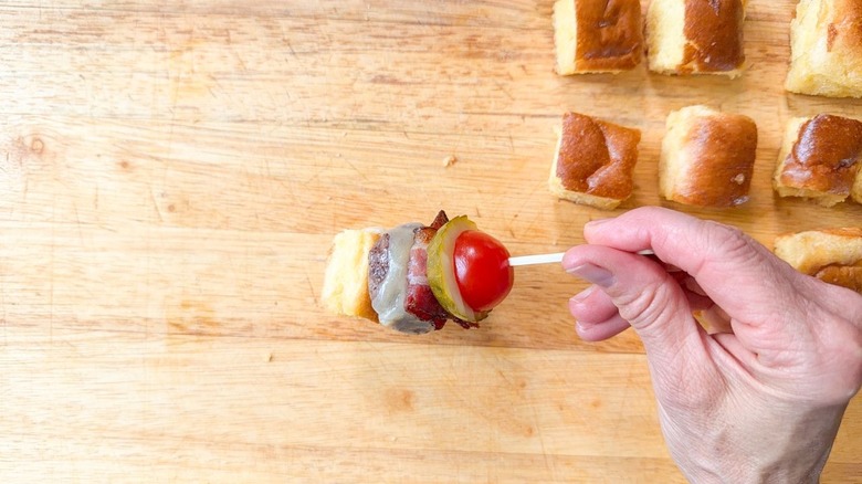 Mini cheeseburger skewer on cutting board