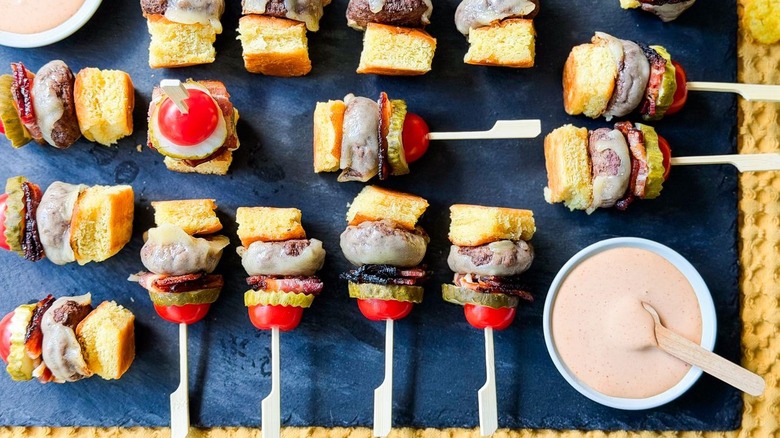 Cheeseburger skewers on slate platter with dipping sauce