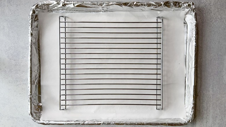 Baking sheet lined with foil and parchment paper and fitted with a rack