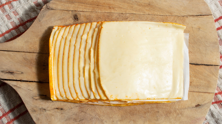 slices of meunster cheese on wooden cutting board