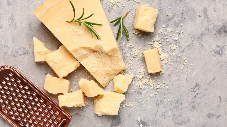 Pieces of Parmesan cheese with grater